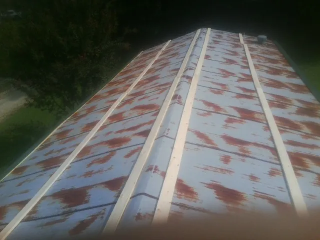 Rusted metal roof panels with new wood purlins before replacement — Storm Damage Roof Repair in Tunnelton by Roofing Brothers