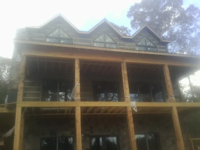 Dormers and porch framing on a large log home under construction — Roof Coating work by our crew in Tunnelton