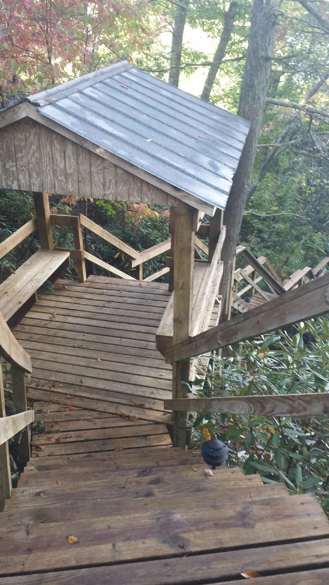 Metal roofed shelter over wooden steps on a wooded walkway — Skylight Repair & Installation work by our crew in Tunnelton