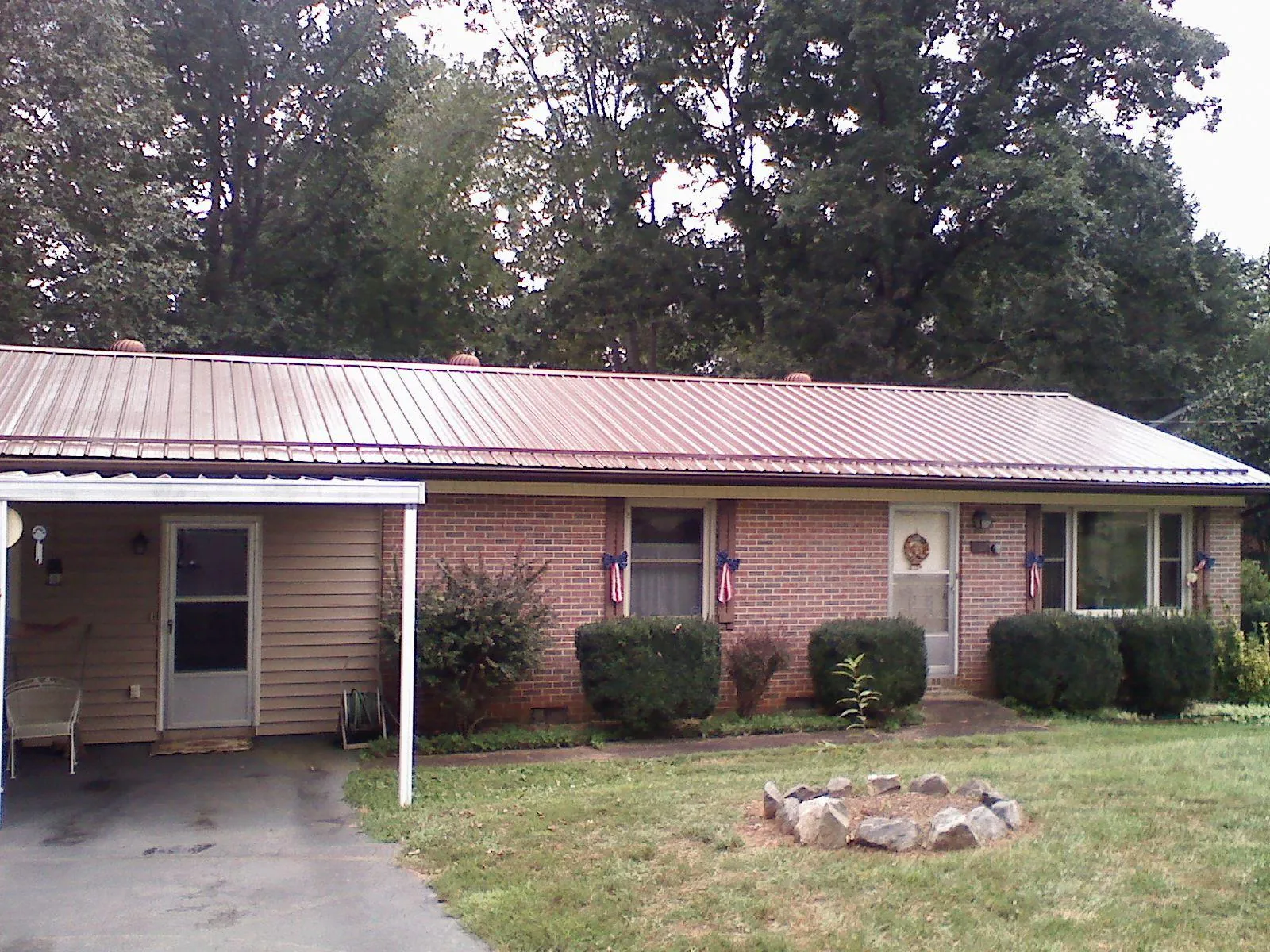Bronze metal roof and carport on a brick ranch home — Roof Repair work by our crew in Tunnelton